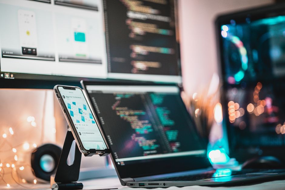 A close-up view of a tech setup with gadgets and coding screen